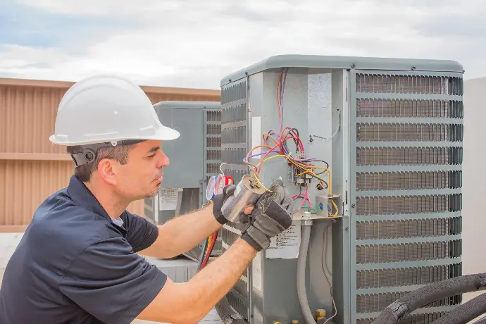 man werkt aan een airco unit